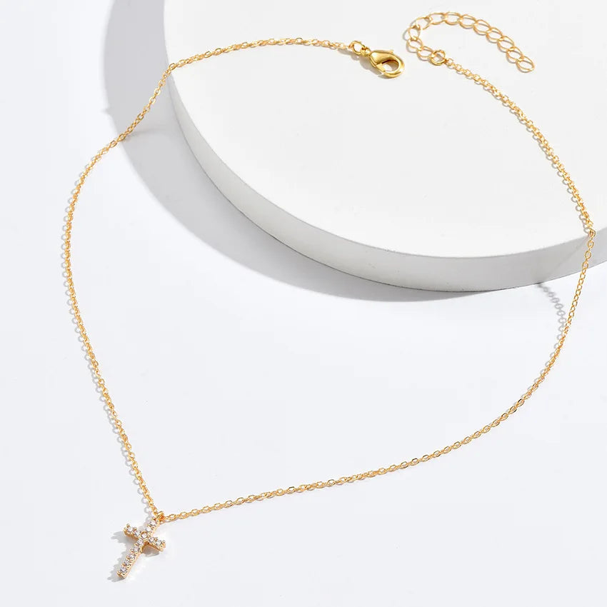 Goldene Kreuzkette mit klar gefassten Zirkon‑Steinen