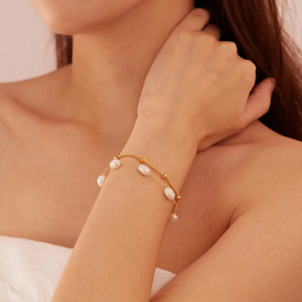 Doppellagiges Perlenarmband mit Edelstahl‑Elementen und glatter Perlenstruktur