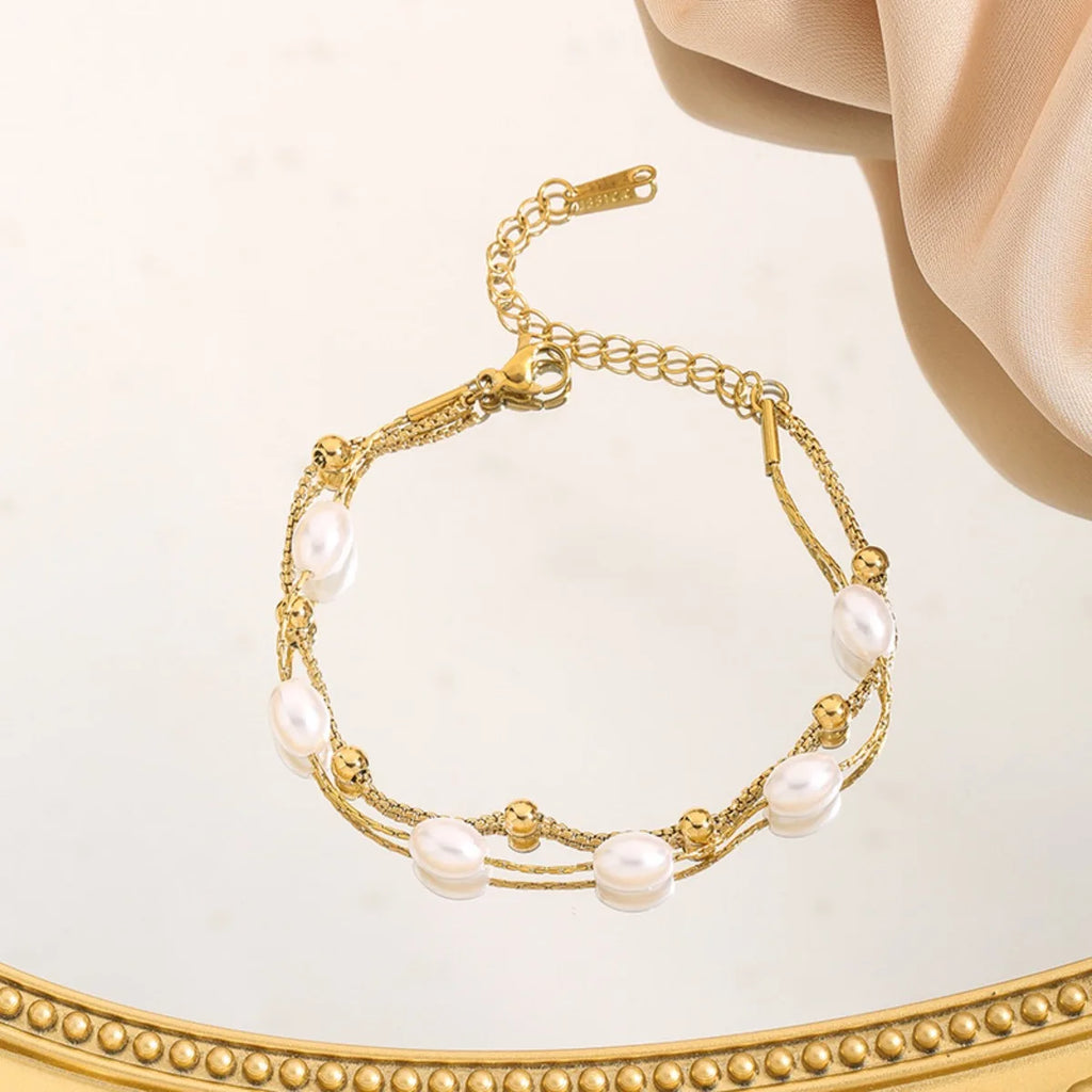 Doppellagiges Perlenarmband mit Edelstahl‑Elementen und glatter Perlenstruktur