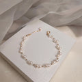 Süßwasserperlenarmband mit goldfarbenem Blumen‑Charm