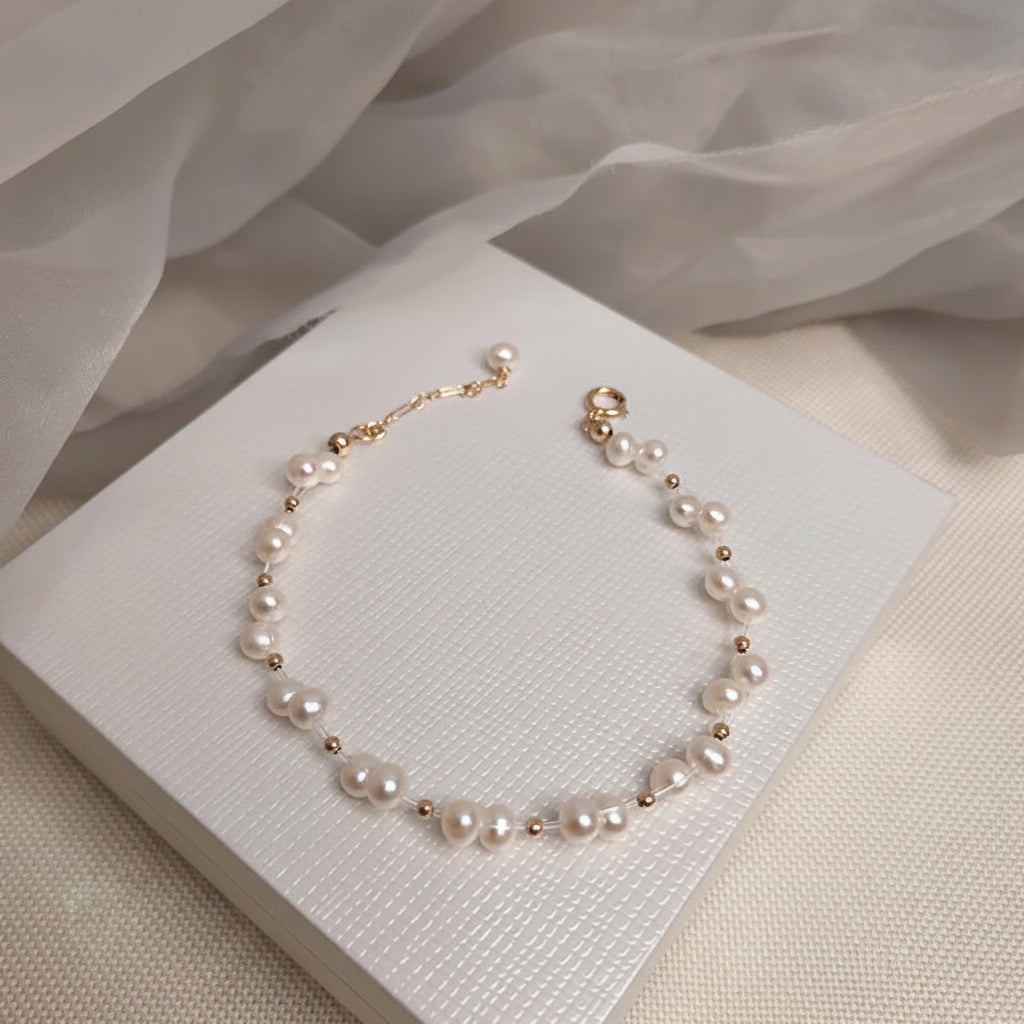 Süßwasserperlenarmband mit goldfarbenem Blumen‑Charm