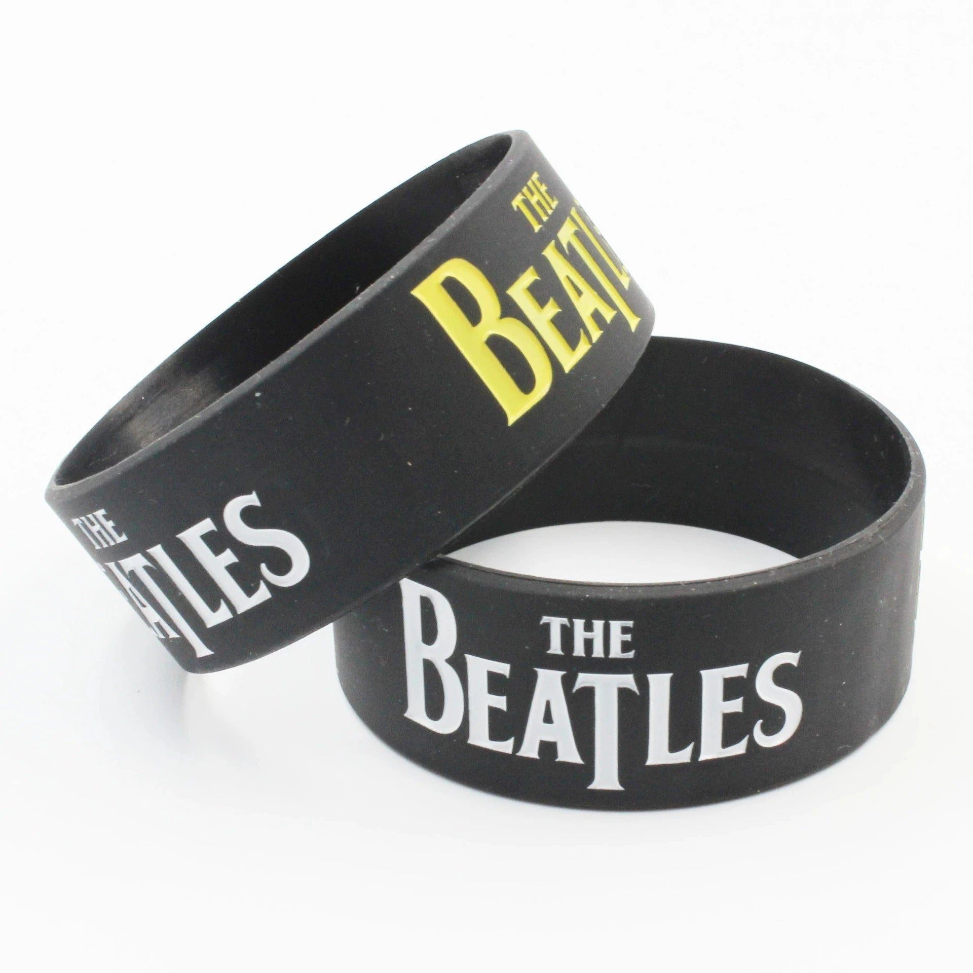 Breites THE BEATLES Silikonarmband aus schwarzem Gummi mit klarem Band‑Logo in 2,5 mm Stärke