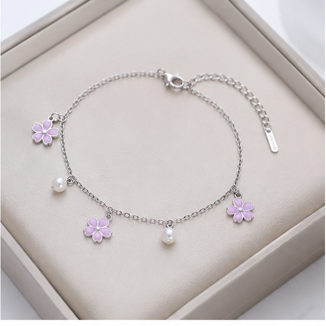 Elegantes Cazador Blumenarmband mit Emaille‑Plumeria und Perlen