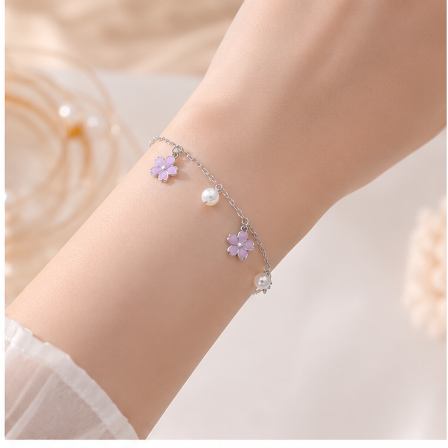 Elegantes Cazador Blumenarmband mit Emaille‑Plumeria und Perlen
